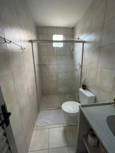 a bathroom with a shower with a toilet and a sink at Jardim Tropical in Bayeux