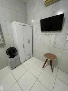 a bathroom with a toilet and a small cabinet and a stool at Jardim Tropical in Bayeux