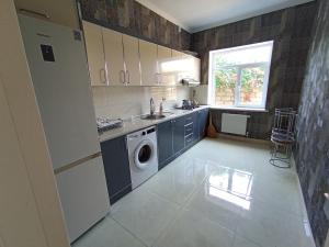 a kitchen with a sink and a washing machine at Qəbələn SNS RENTAL VILLA in Gabala