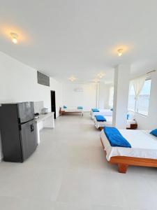 a large room with four beds and a refrigerator at Marina Suite in Puerto Ayora