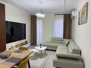 a living room with a couch and a table at Valentinas Apartment in Korçë