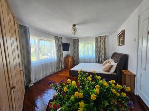 a bedroom with a bed and a couch and flowers at Cabana GRAD in Săliştea de Sus +240 photos