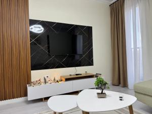 a living room with a tv on a wall at Valentinas Apartment in Korçë +1 photo