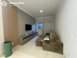 a living room with a couch and a tv at Casa Premium Adamantina in Adamantina