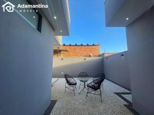 three chairs and a glass table on a patio at Casa Premium Adamantina in Adamantina