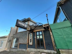 un bâtiment avec une enseigne sur la façade dans l'établissement Hotel Low Cost "Colón", à Punta Arenas