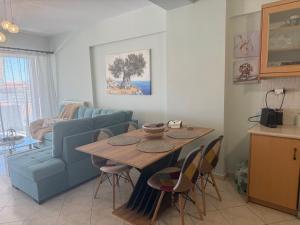 a living room with a table and a blue couch at Ethereal Apartment in Xylokastro
