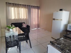 a small kitchen with a table and a refrigerator at Casa Prizon in Olímpia