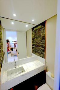 マタ・デ・サン・ジョアンにあるBeach Front Luxury, Praia do Forte, Feet in the Sand!の白い洗面台と鏡のあるバスルーム