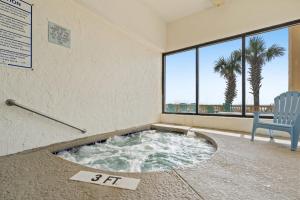 a jacuzzi tub in a room with a chair at Sea Pointe 507 - Oceanfront in Myrtle Beach
