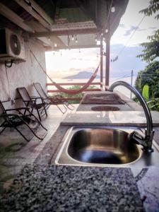 a kitchen with a sink and chairs on a patio at Casa Wili Taboga in Taboga