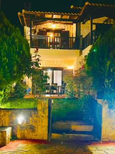 a house with a balcony with a table and chairs at Afytos house in Afitos