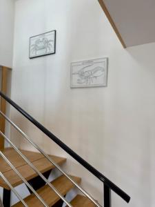 two framed drawings of animals on a wall next to stairs at Ty Kermaudez in Paimpol