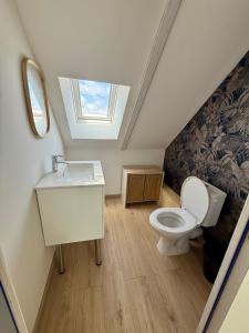 a bathroom with a toilet and a sink and a window at Ty Kermaudez in Paimpol