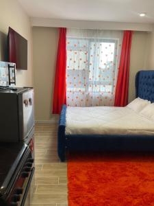 Un dormitorio con una cama y una ventana con cortinas rojas. en Whitelily Homes, en Marimbeti 16 fotos más