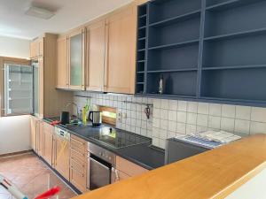 una cucina con armadi in legno e ripiani neri di Grosses Haus bei München mit 4 Schlafzimmern für bis zu 10 Personen a Gauting