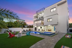 a large white house with a patio and a pool at Ocean Muse - Lux Waterfront Escape - Pool - Dock in Marathon