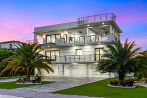 a large house with palm trees in front of it at Ocean Muse - Lux Waterfront Escape - Pool - Dock in Marathon