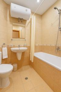 a bathroom with a toilet and a sink and a bath tub at Velika Garden Villas 1 bedroom apartment, Lozenets in Lozenets