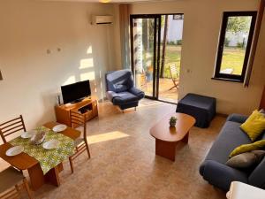 a living room with a couch and a table and chairs at Velika Garden Villas 1 bedroom apartment, Lozenets in Lozenets