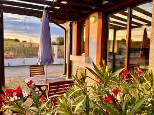 a patio with an umbrella and a table with flowers at Velika Garden Villas 1 bedroom apartment, Lozenets in Lozenets