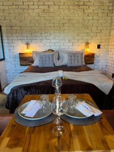 a hotel room with a bed with two glasses on a table at Pousada do valle in Monte Verde