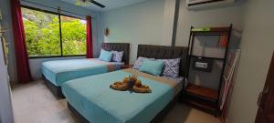 1 Schlafzimmer mit 2 Betten mit Teddybären auf dem Bett in der Unterkunft Ballena Rey Hotel in Uvita + 151 Fotos