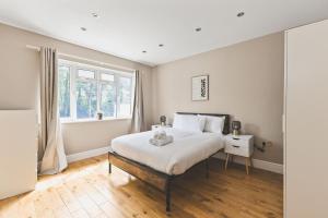 a bedroom with a bed with a teddy bear on it at Bright 2bed flat near station - COU A in Coulsdon