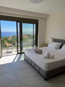 a bedroom with a large bed with a view of the ocean at Thalassa Haven Lourdas in Lourdhata +44 photos