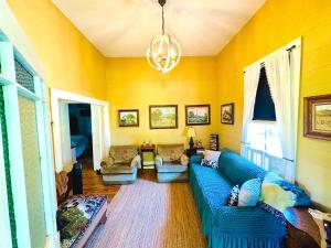 a living room with a blue couch and a chandelier at Circa 1900 - Historic - Romantic - Private - Pond - Fenced Yard - The Cottage at Chappell Hill in Chappell Hill