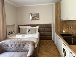 a small bedroom with a bed and a sink at Apartamenty Uchnasta in Busko-Zdrój