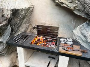 a grill sitting on a table next to a rock at Sweet Home 119 spa privé in Château-Ville-Vieille