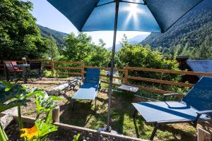a patio with two chairs and an umbrella at Sweet Home 119 spa privé in Château-Ville-Vieille