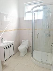 a bathroom with a shower and a toilet and a sink at Family Perfect - Lovely New 2-Bedroom Apartment in Vacoas