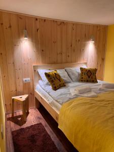 a bedroom with a large bed with wooden walls at Wolf Apartments near Biogradska Gora in Mojkovac