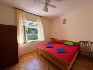 a bedroom with a red bed and a window at Hostel Guesthouse Mira in Omiš +21 photos