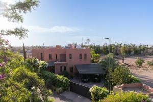 a house in the middle of a desert with trees at Villa centre Marrakech piscine sans vis-à-vis et Jacuzzi in Marrakech