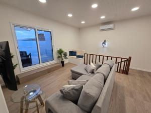 un soggiorno con un divano e una TV di Brisa do Mar Azorean House a Maia