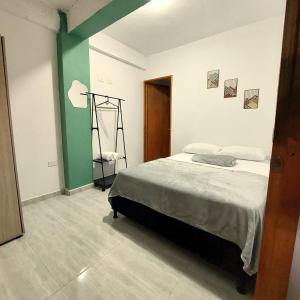 a bedroom with a bed and a green accent wall at Apartamento en jardin in Jardin
