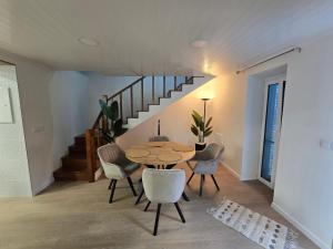 a dining room with a table and chairs and a staircase at Brisa do Mar Azorean House in Maia