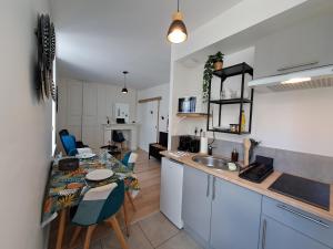 a kitchen with a table and a dining room at L'Envolée, Proche Gare SNCF, Confort, Netflix in Laval