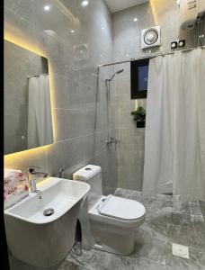 a bathroom with a toilet and a sink and a shower at Modern Apartment in Jeddah +32 photos