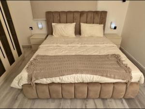 a large bed with a large headboard in a bedroom at Modern Apartment in Jeddah