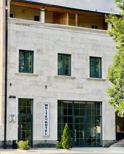 a building with windows and a sign on it at WHITE HOTEL GYUMRI in Gyumri