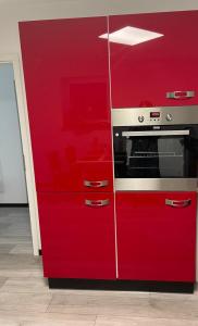 a red cabinet with a microwave in it at Ferienwohnung Waldblick 2 für 4 Personen und max 2 Hunde in Simmerath