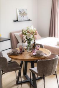 un tavolino con un vaso di fiori sopra di La Tereza Apartments a Ķesterciems