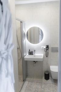 a bathroom with a sink and a mirror at La Tereza Apartments in Ķesterciems