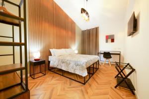 a bedroom with a bed and a desk in it at Via Manno 11 Rooms in Iglesias