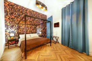 a bedroom with a canopy bed and a colorful wall at Via Manno 11 Rooms in Iglesias