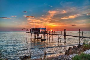 a dock in the water with the sunset in the background at Dimora Tra Mare e Montagna in Lanciano
